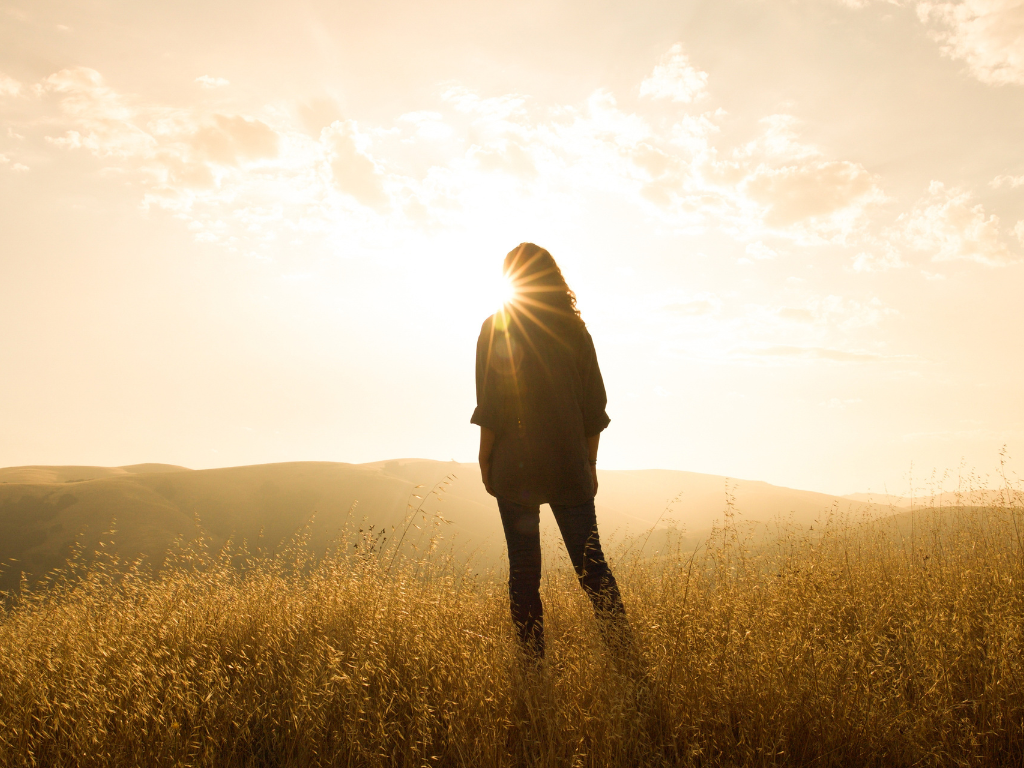 woman standing in front of sunset